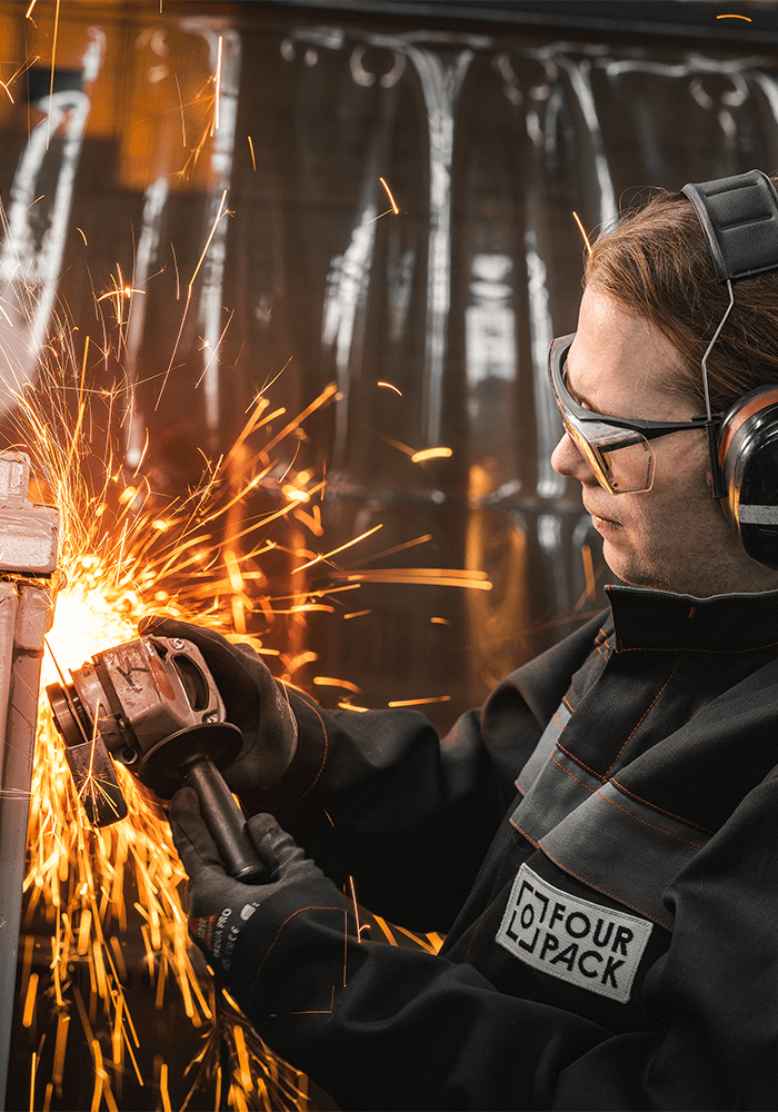 Mitarbeiter von FOUR PACK beim Schweißen, Funken sprühen.