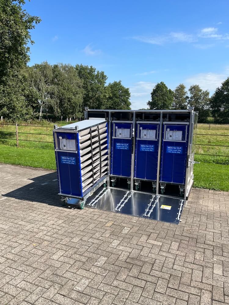 Aluminium-Transportcontainer mit vier blauen Transportwagen