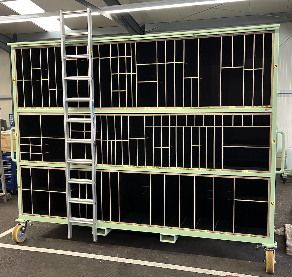 Stahlwagen mit Holz Gefache zur Aufnahme verschiedener Bauteile und außen angebrachter Leiter