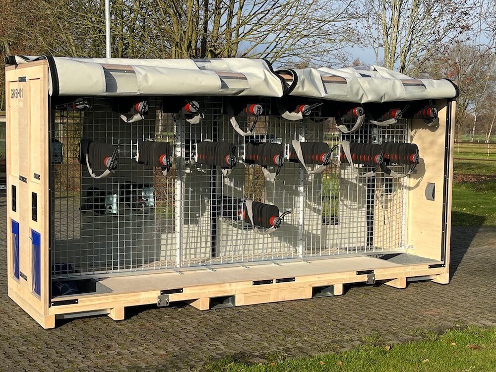 Große Holzkiste mit Metallgittern und flexiblen Bauteilaufnahmen