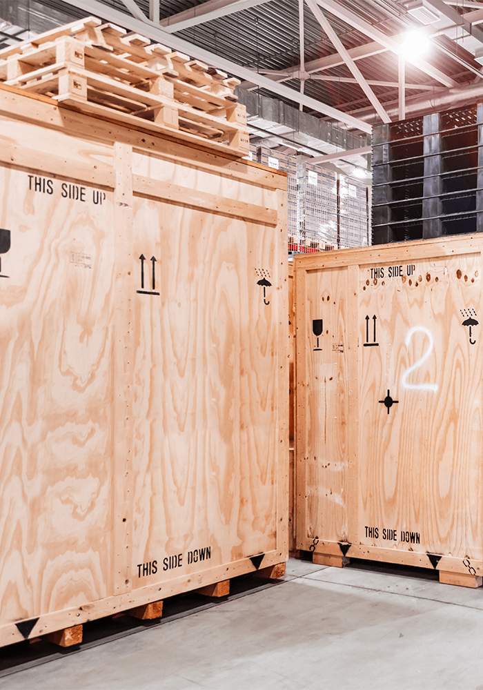 Large wooden boxes on pallets in an industrial hall of FOUR PACK
