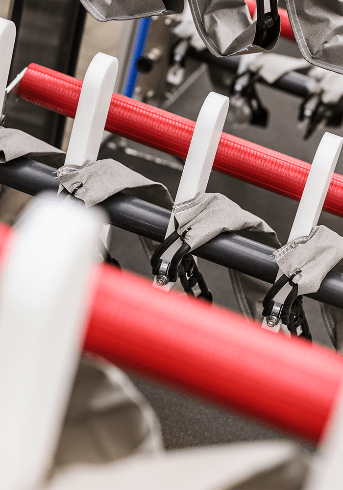 Red pipes with white brackets in a production hall.