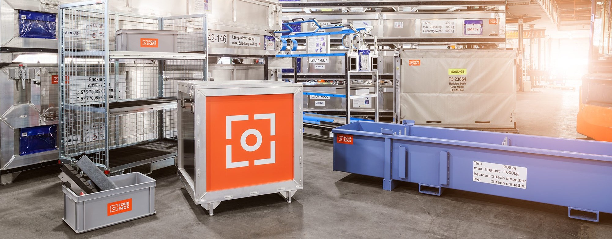 Vier Mitarbeiter von FOUR PACK sitzen an einem Tisch und besprechen Unterlagen.